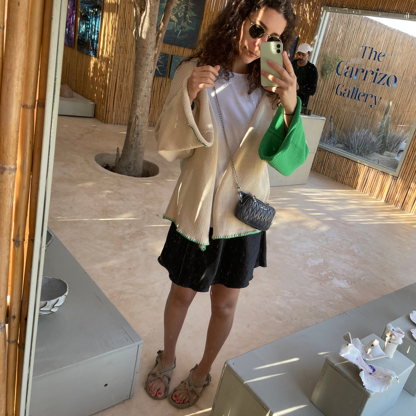 givéh knitwear handmade by female artisans in iran using only natural and recycled fibres. contemporary knitwear for cool people. cream the cardi, cream and green knit cardigan with belt made of cotton and recycled polyamide yarn. spring summer 2025 collection.