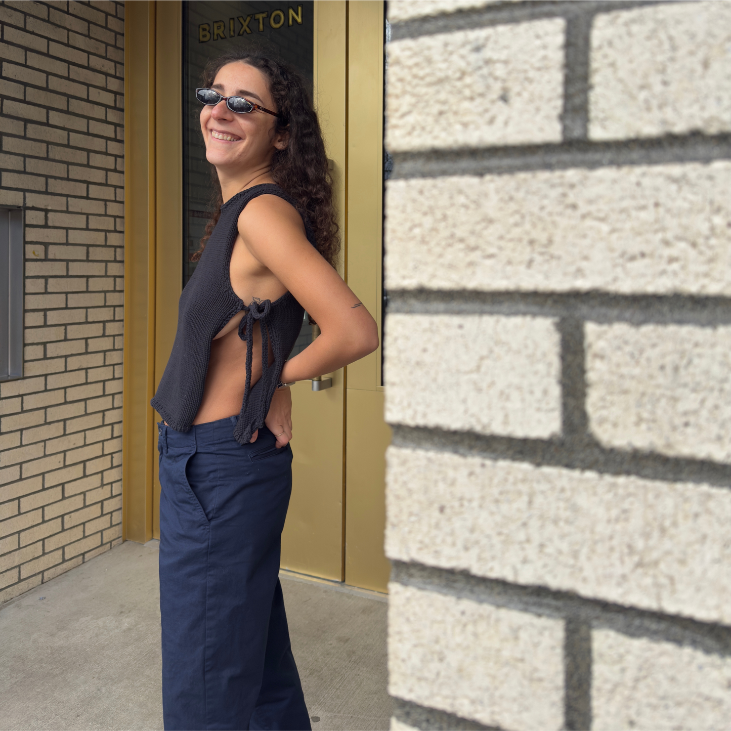 givéh knitwear handmade by female artisans in iran using only natural and recycled fibres. contemporary knitwear for cool people. black tie top, black open side top with tie closure and hand crocheted edges made out of cotton and recycled polyamide yarn. spring summer 2025 collection.