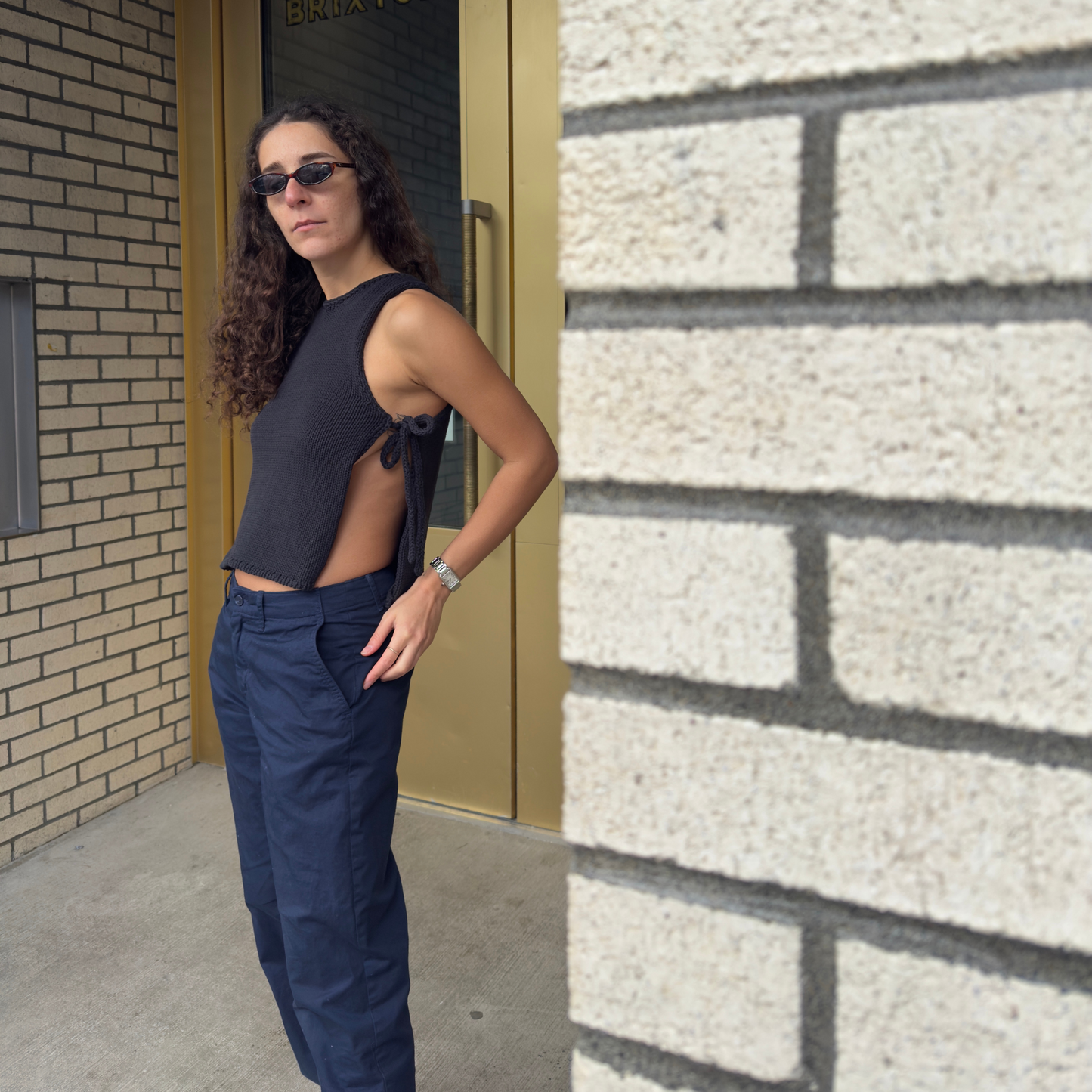 givéh knitwear handmade by female artisans in iran using only natural and recycled fibres. contemporary knitwear for cool people. black tie top, black open side top with tie closure and hand crocheted edges made out of cotton and recycled polyamide yarn. spring summer 2025 collection.