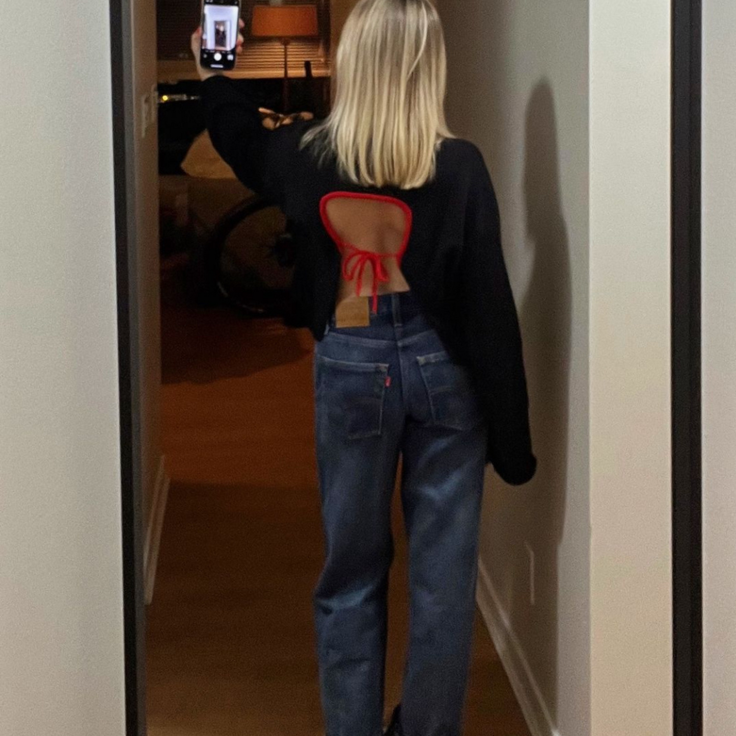 Person wearing a black jacket with a unique back design, standing in front of a mirror.
Person wearing a black jacket over a red bikini top and blue jeans, standing against a neutral background.
givéh knitwear handmade by female artisans in iran using only natural and recycled fibres. contemporary knitwear for cool people. crewneck backless sweater in black. 100% merino wool. fall 2025 collection.