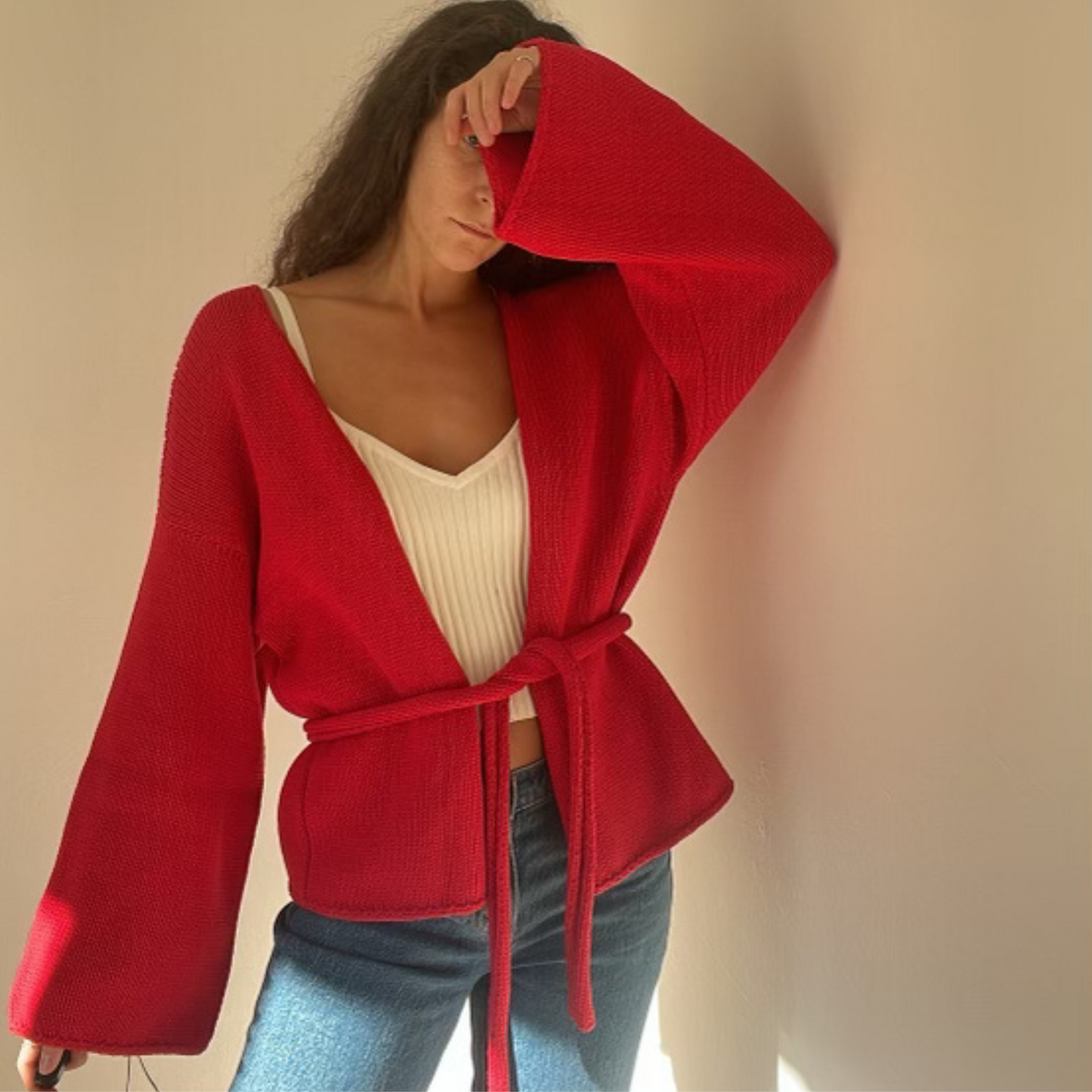 givéh knitwear handmade by female artisans in iran using only natural and recycled fibres. contemporary knitwear for cool people. chili the cardi, red knit cardigan with belt made of cotton and recycled polyamide yarn. spring summer 2025 collection.