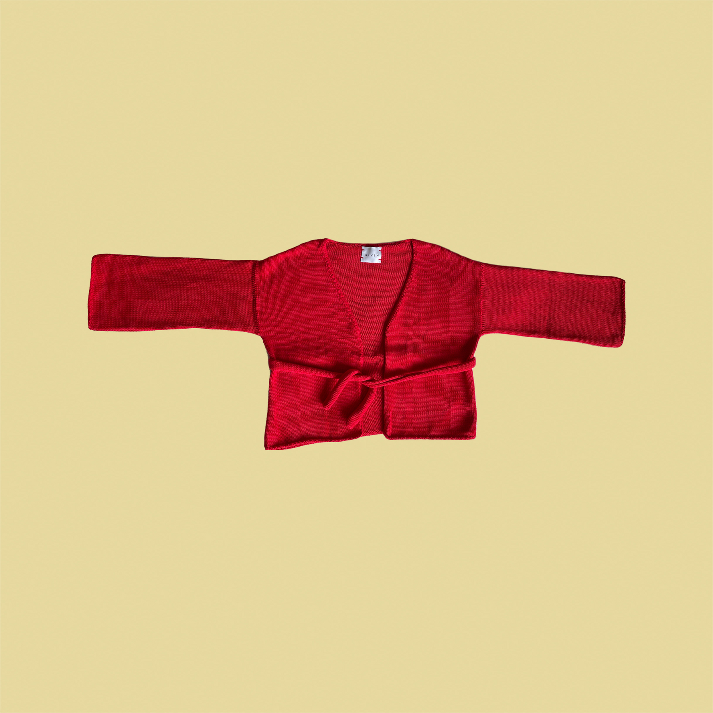 givéh knitwear handmade by female artisans in iran using only natural and recycled fibres. contemporary knitwear for cool people. chili the cardi, red knit cardigan with belt made of cotton and recycled polyamide yarn. spring summer 2025 collection.