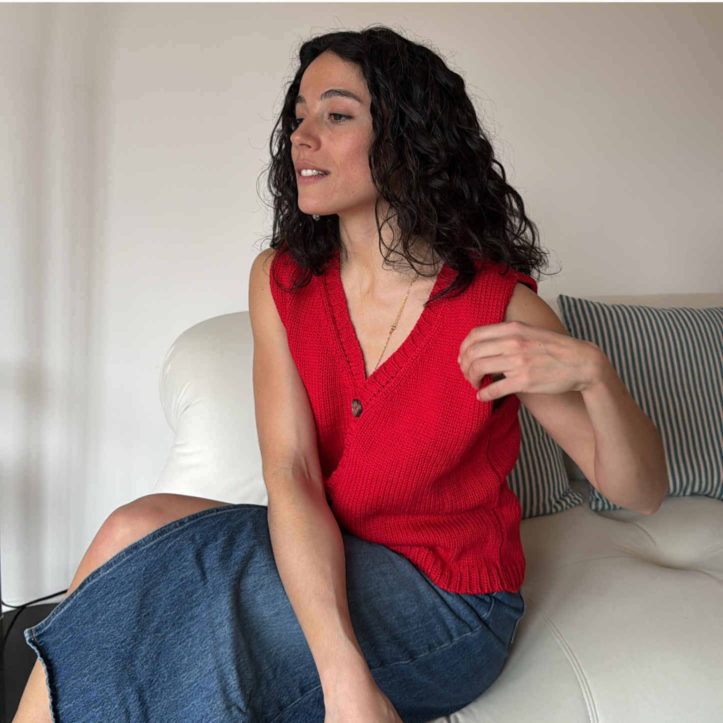givéh knitwear handmade by female artisans in iran using only natural and recycled fibres. contemporary knitwear for cool people. red vesty vest, red knit vest with three natural horn buttons, made of cotton and recycled polyamide yarn, handcrocheted edges. spring summer 2025 collection.