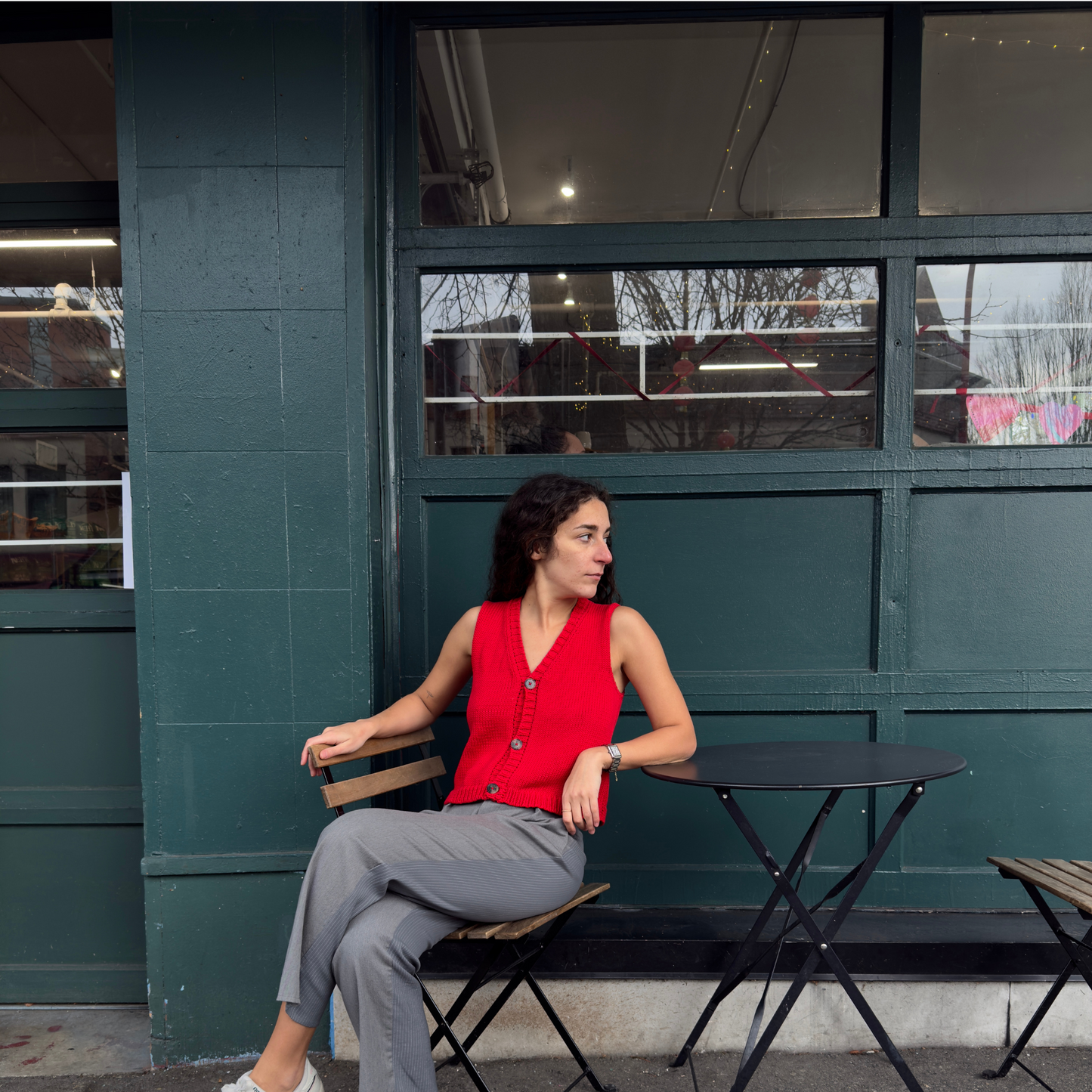 givéh knitwear handmade by female artisans in iran using only natural and recycled fibres. contemporary knitwear for cool people. red vesty vest, red knit vest with three natural horn buttons, made of cotton and recycled polyamide yarn, handcrocheted edges. spring summer 2025 collection.
