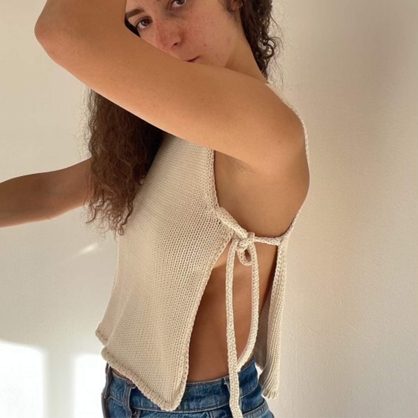 givéh knitwear handmade by female artisans in iran using only natural and recycled fibres. contemporary knitwear for cool people. cream tie top, cream open side top with tie closure and hand crocheted edges made out of cotton and recycled polyamide yarn. spring summer 2025 collection.