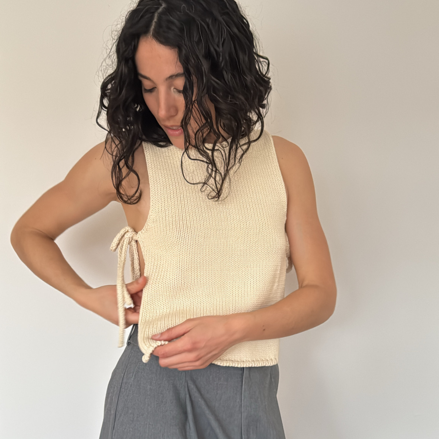 givéh knitwear handmade by female artisans in iran using only natural and recycled fibres. contemporary knitwear for cool people. cream tie top, cream open side top with tie closure and hand crocheted edges made out of cotton and recycled polyamide yarn. spring summer 2025 collection.