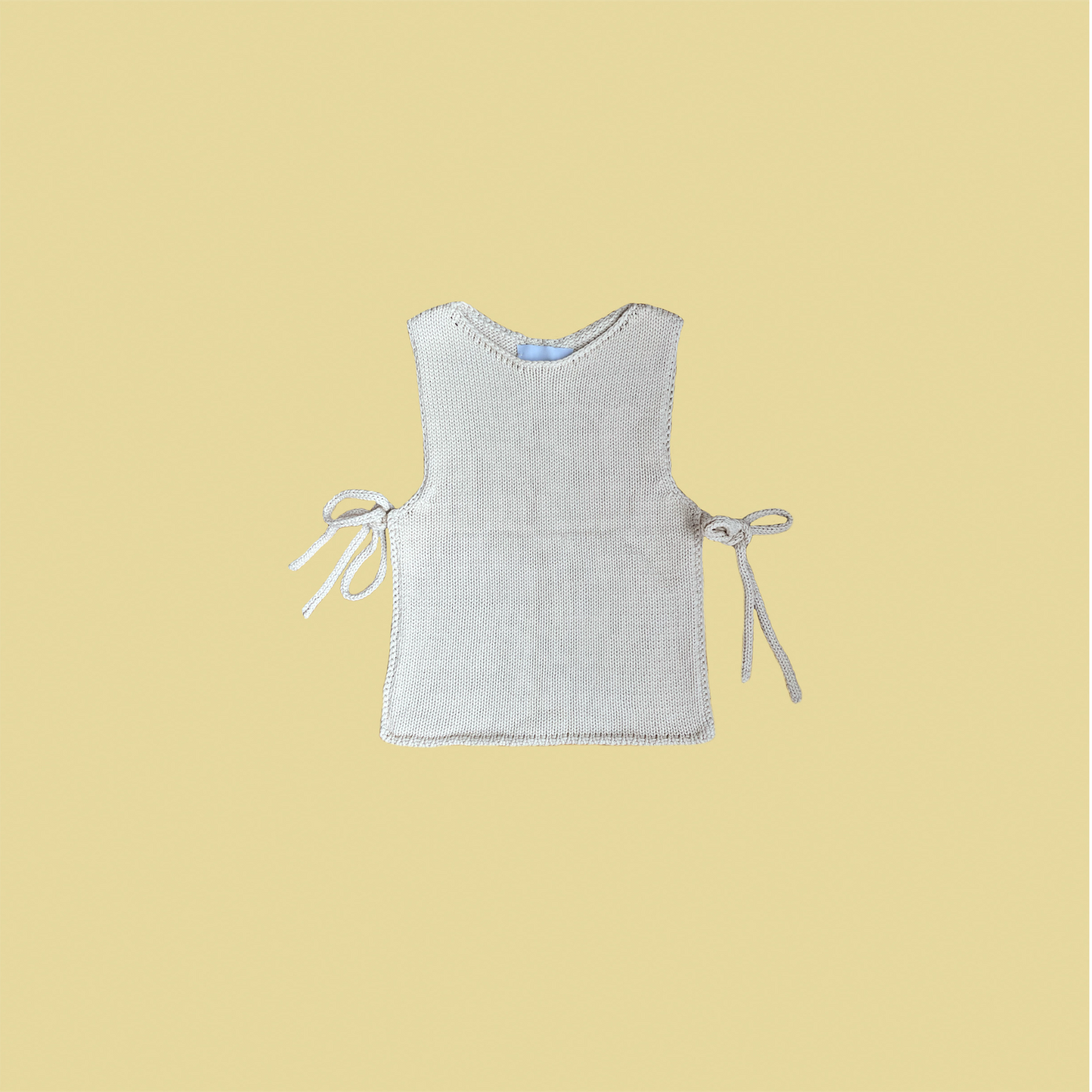 givéh knitwear handmade by female artisans in iran using only natural and recycled fibres. contemporary knitwear for cool people. cream tie top, cream open side top with tie closure and hand crocheted edges made out of cotton and recycled polyamide yarn. spring summer 2025 collection.