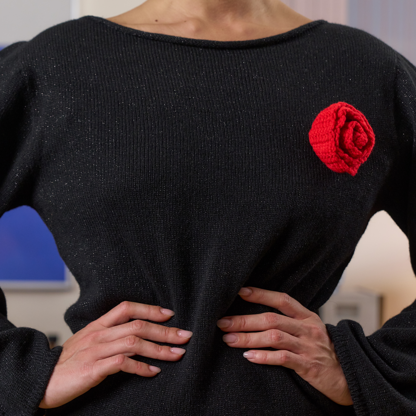 givéh knitwear handmade by female artisans in iran using only natural and recycled fibres. contemporary knitwear for cool people. black dress with red hand crocheted flower. made of merino wool. fall 2025 collection.