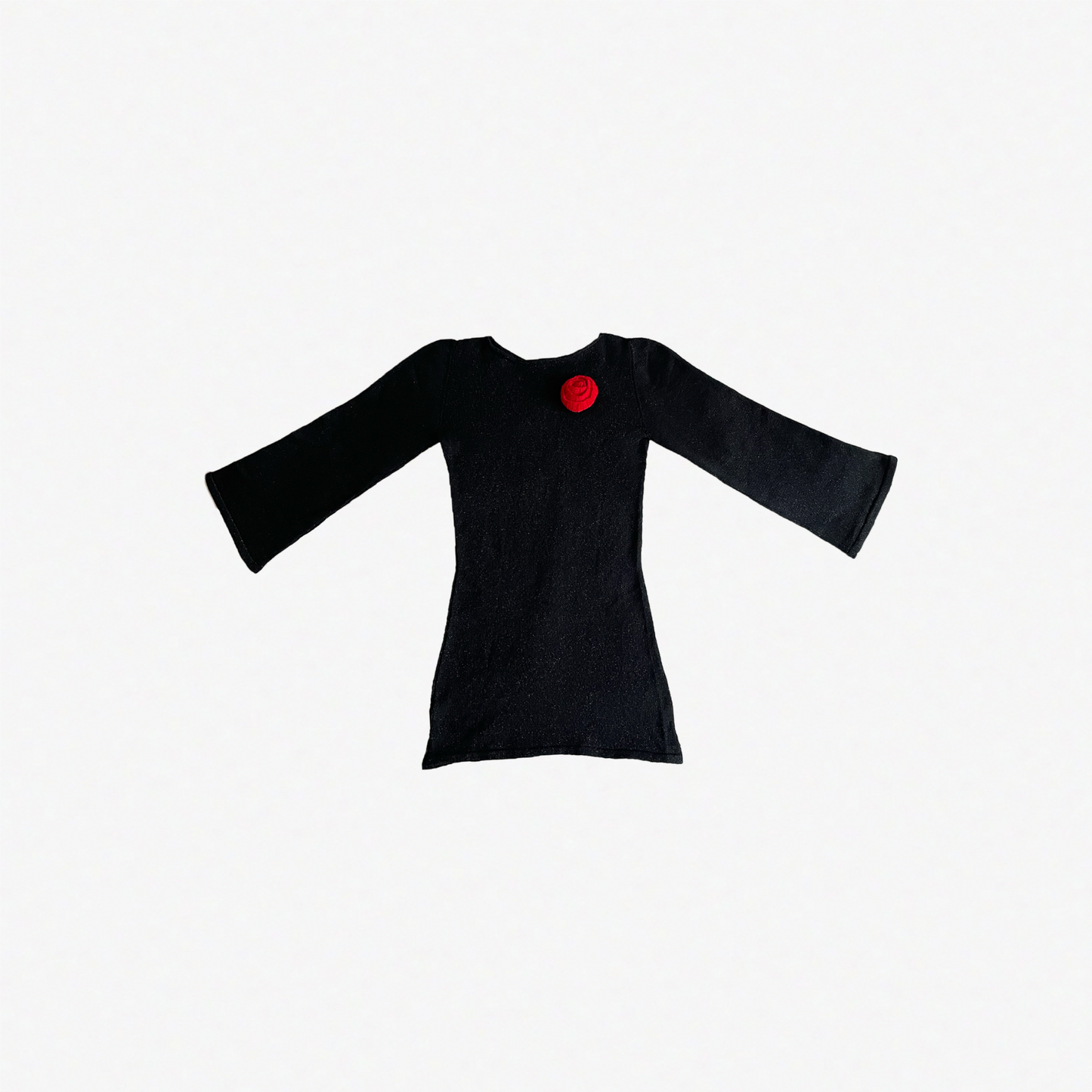 givéh knitwear handmade by female artisans in iran using only natural and recycled fibres. contemporary knitwear for cool people. black dress with red hand crocheted flower. made of merino wool. fall 2025 collection.