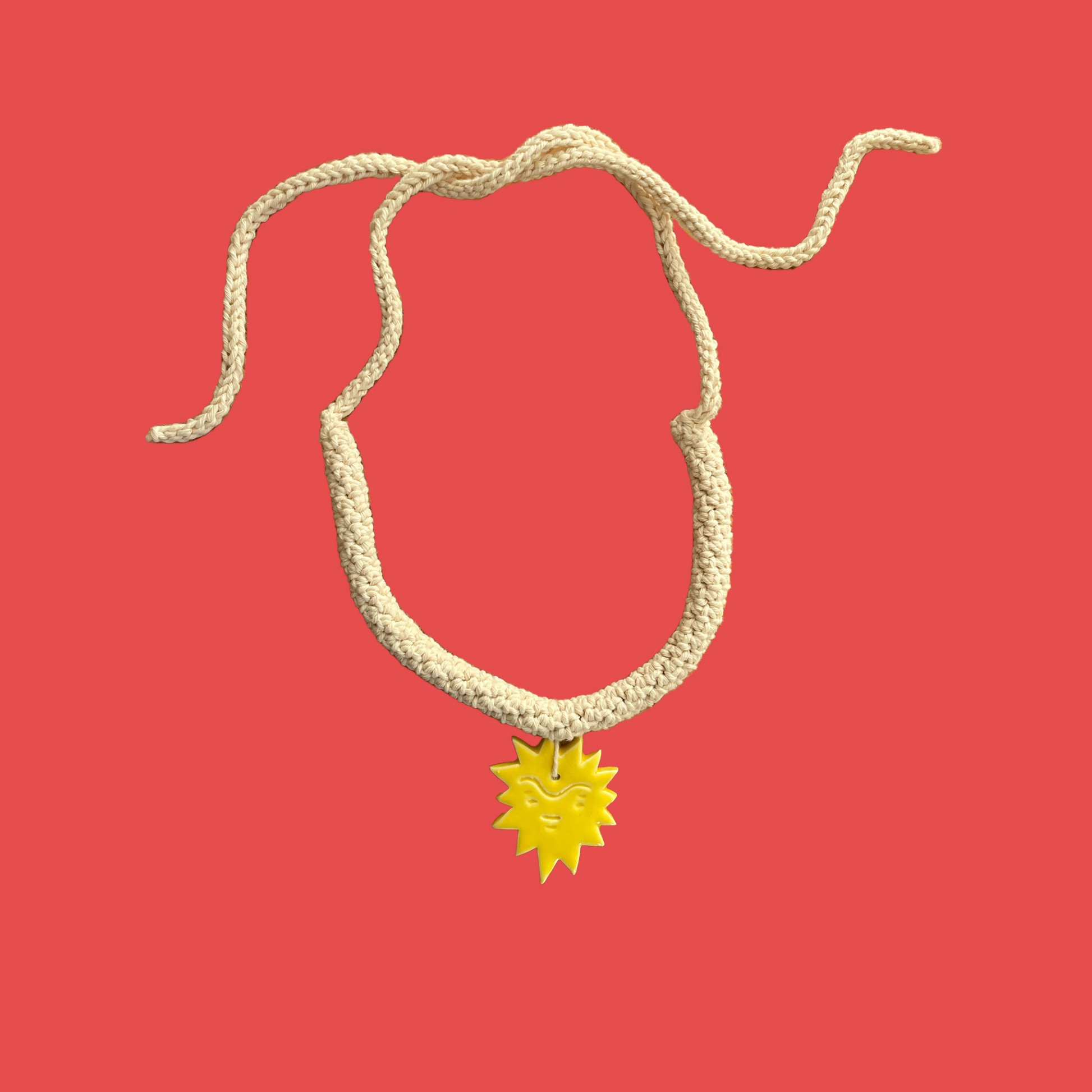 givéh knitwear handmade by female artisans in iran. aftab hand crocheted undyed cotton necklace with handmade clay ceramic pendant in the shape of the sun.