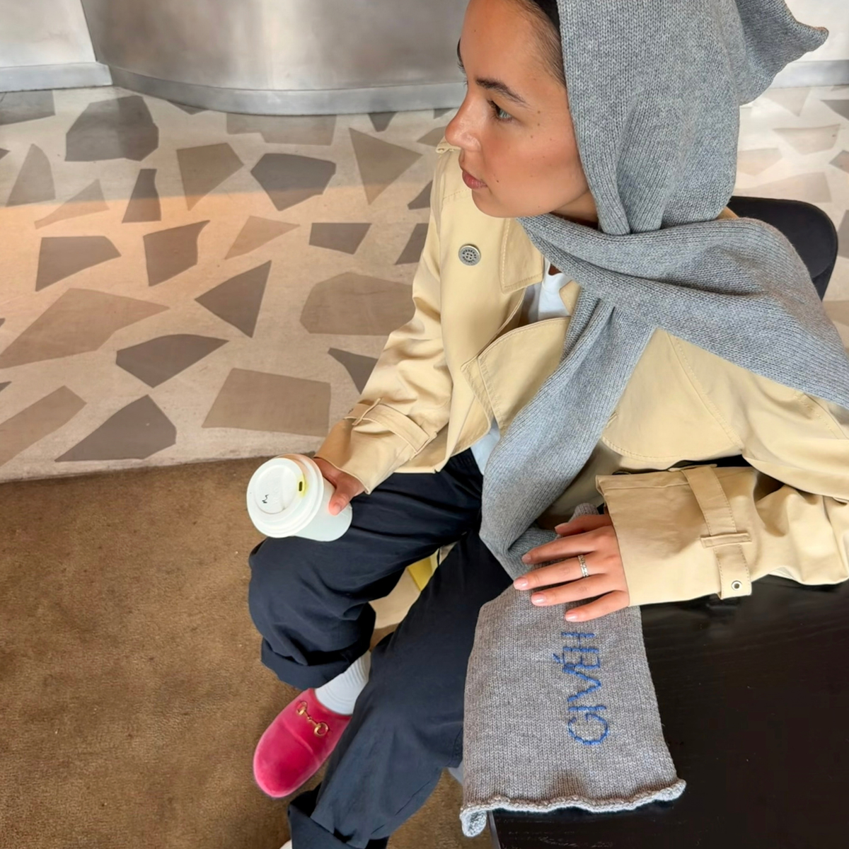 Givéh handmade merino wool cashmere-blend hooded scarf by female artisans in Iran, hand embroidered detail in grey, shown worn on model