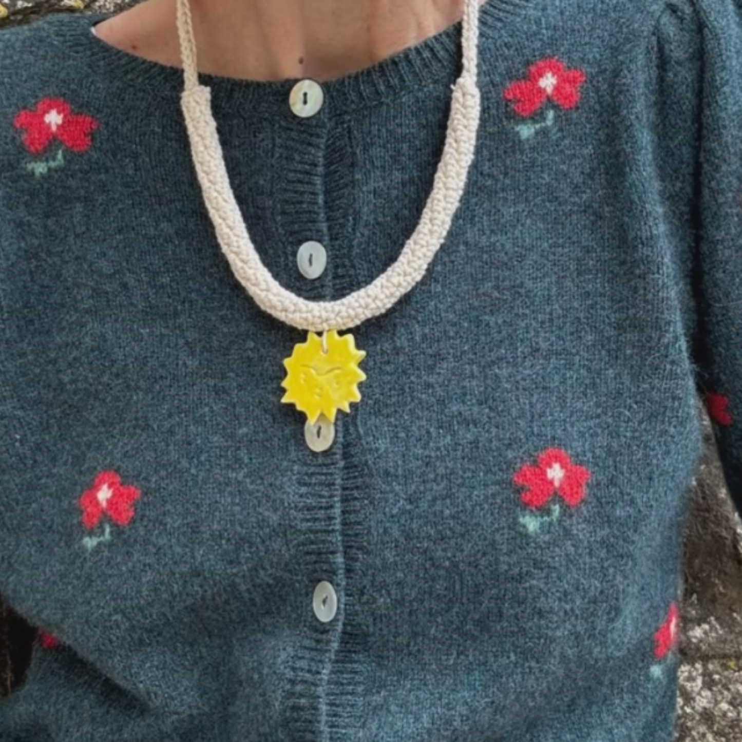 givéh knitwear handmade by female artisans in iran. aftab hand crocheted undyed cotton necklace with handmade clay ceramic pendant in the shape of the sun.
