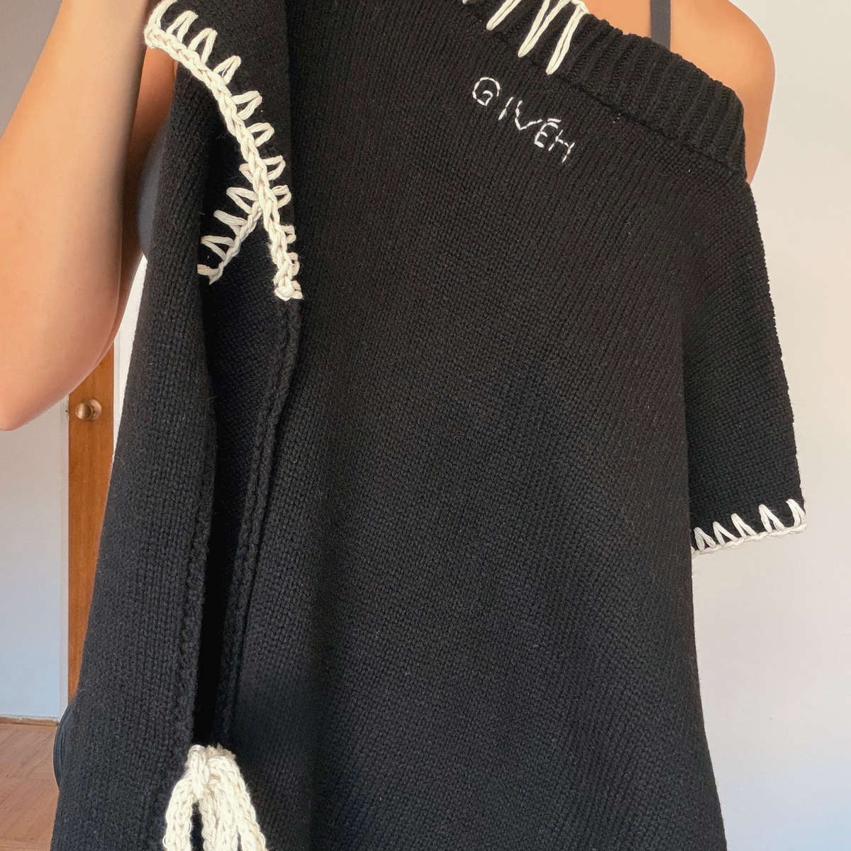 Givéh handmade merino wool cashmere-blend open-side vest by female artisans in Iran, black with cream hand crocheted trim and tie closure
