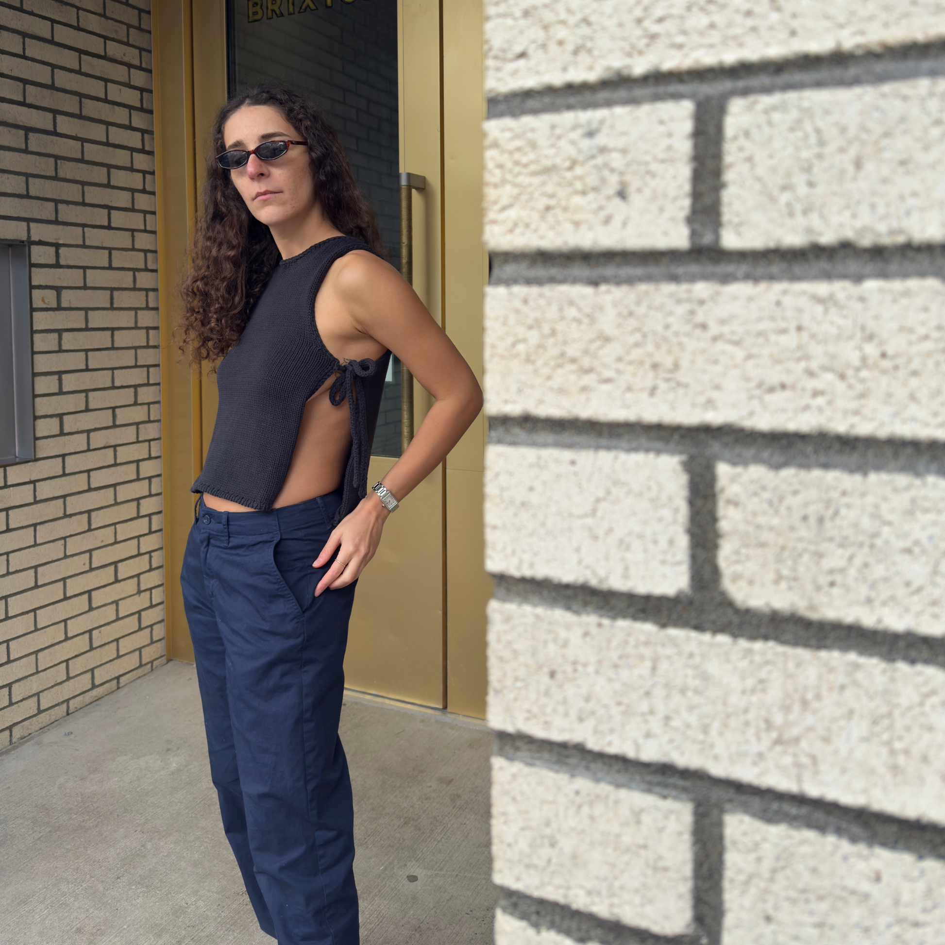 givéh knitwear handmade by female artisans in iran using only natural and recycled fibres. contemporary knitwear for cool people. black tie top, black open side top with tie closure and hand crocheted edges made out of cotton and recycled polyamide yarn. spring summer 2025 collection.