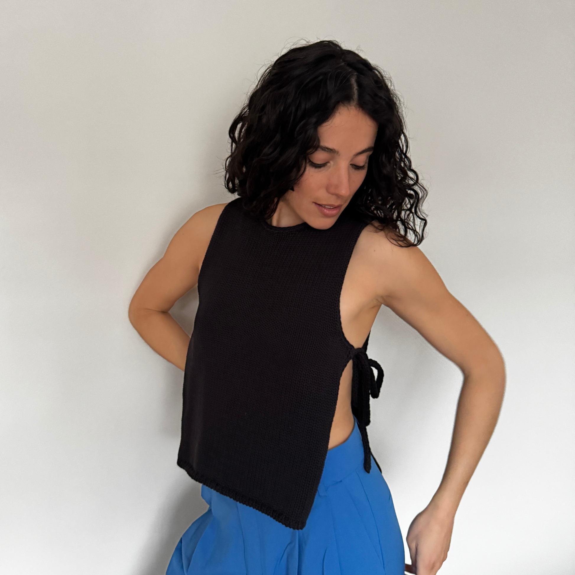 givéh knitwear handmade by female artisans in iran using only natural and recycled fibres. contemporary knitwear for cool people. black tie top, black open side top with tie closure and hand crocheted edges made out of cotton and recycled polyamide yarn. spring summer 2025 collection.