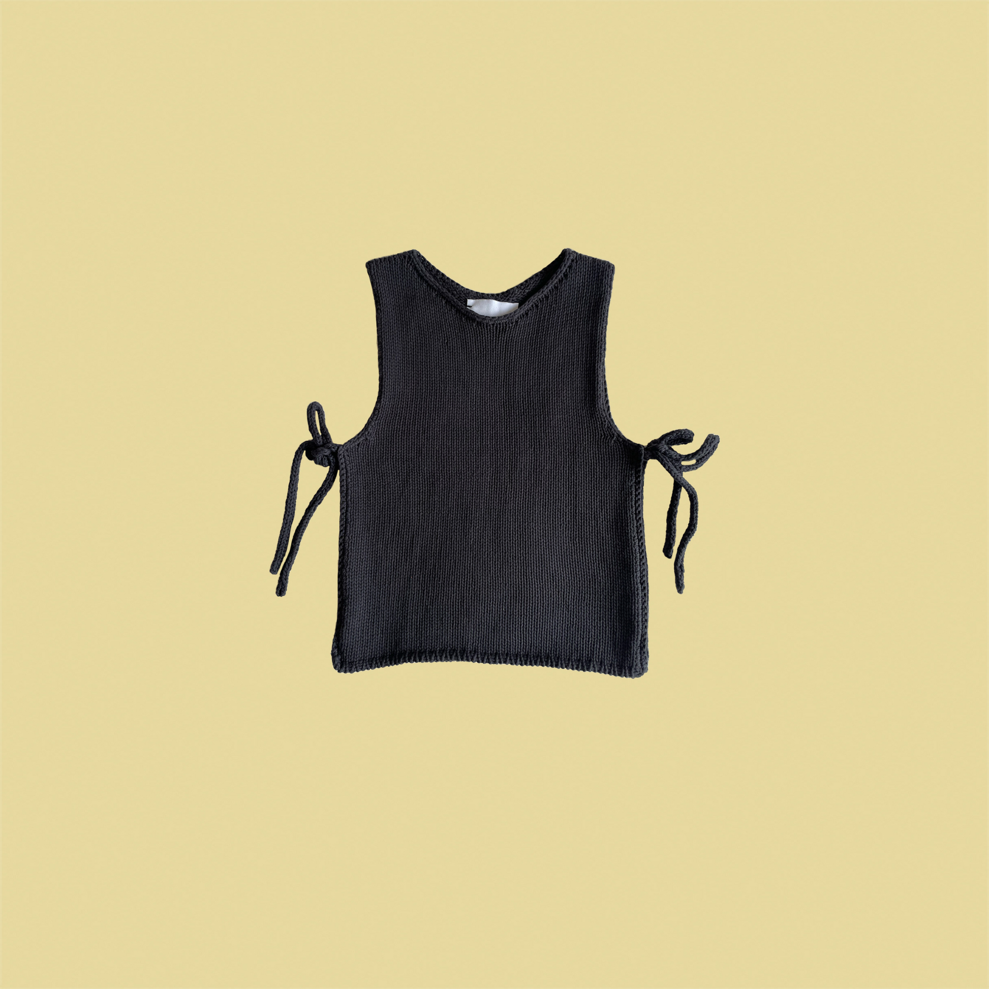 givéh knitwear handmade by female artisans in iran using only natural and recycled fibres. contemporary knitwear for cool people. black tie top, black open side top with tie closure and hand crocheted edges made out of cotton and recycled polyamide yarn. spring summer 2025 collection.