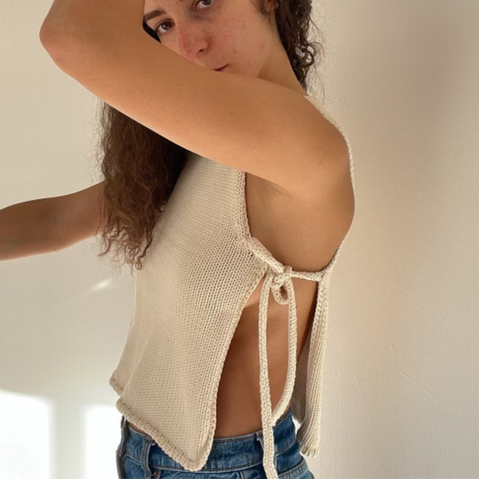 givéh knitwear handmade by female artisans in iran using only natural and recycled fibres. contemporary knitwear for cool people. cream tie top, cream open side top with tie closure and hand crocheted edges made out of cotton and recycled polyamide yarn. spring summer 2025 collection.