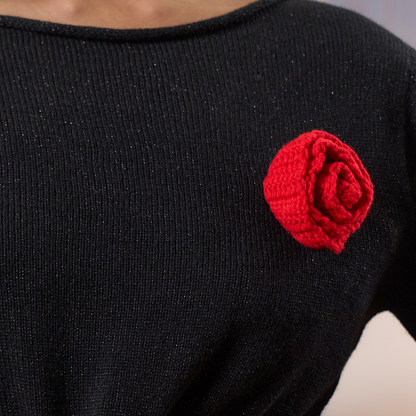 givéh knitwear handmade by female artisans in iran using only natural and recycled fibres. contemporary knitwear for cool people. black dress with red hand crocheted flower. made of merino wool. fall 2025 collection.