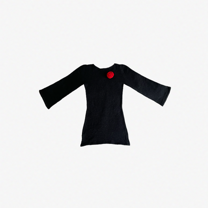 givéh knitwear handmade by female artisans in iran using only natural and recycled fibres. contemporary knitwear for cool people. black dress with red hand crocheted flower. made of merino wool. fall 2025 collection.